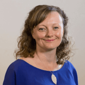 Ali Vipond, CAP's Policy and Public Affairs Officer, smiling at the camera. She has pale skin, shoulder-length wavy brown hair, and is wearing a royal blue blouse.