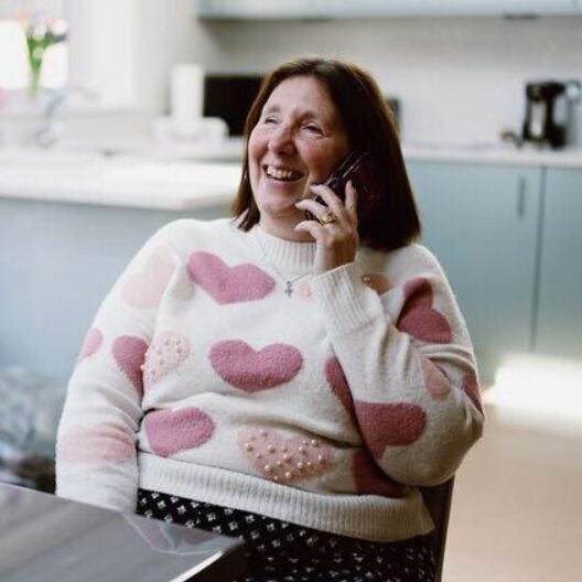 CAP client sat in her kitchen on the phone, smiling