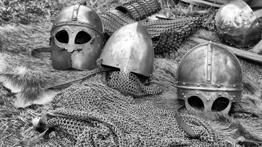 A selection of helmets and other body armour laying on the ground.