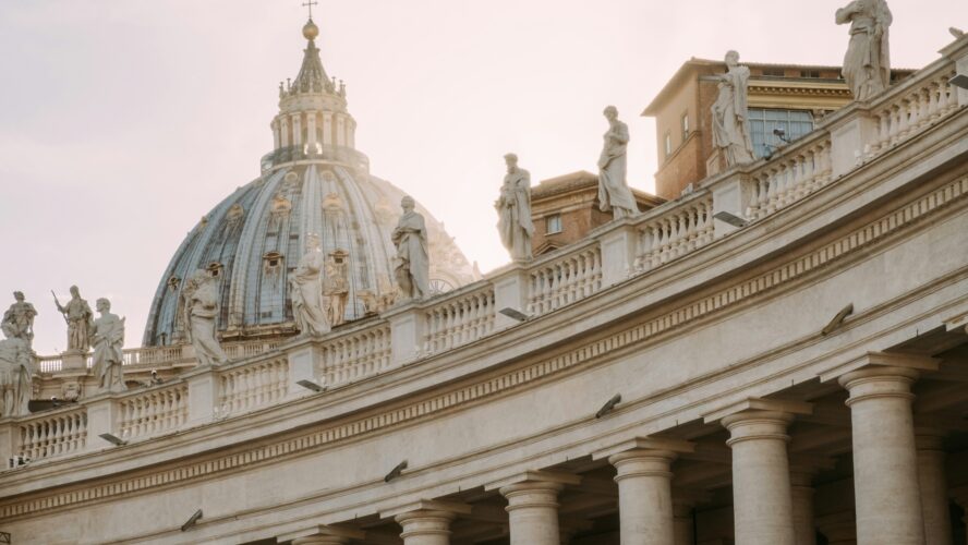 Image of Vatican City dome with sunrise behind it