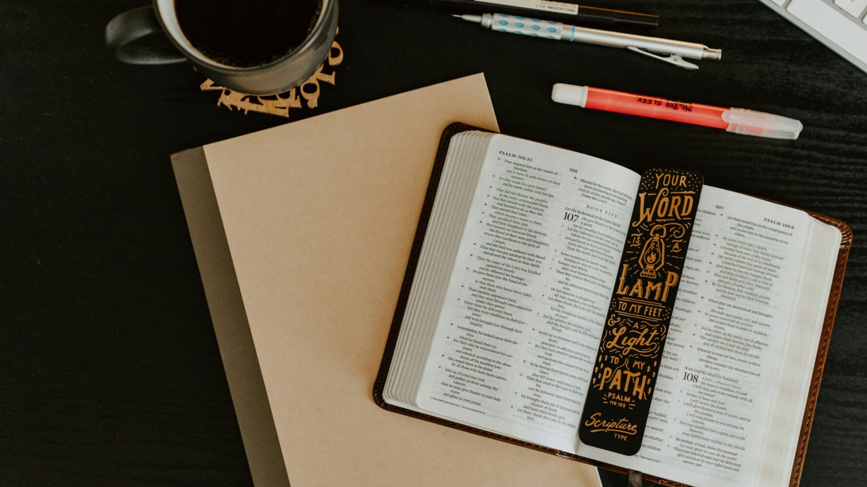 Image of a Bible on a table with a cup of coffee next to it, and a plain piece of paper