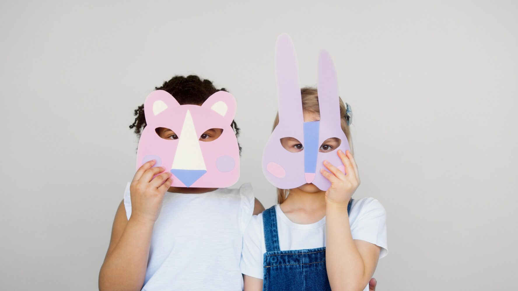 Image of two children wearing handmade animal facemasks