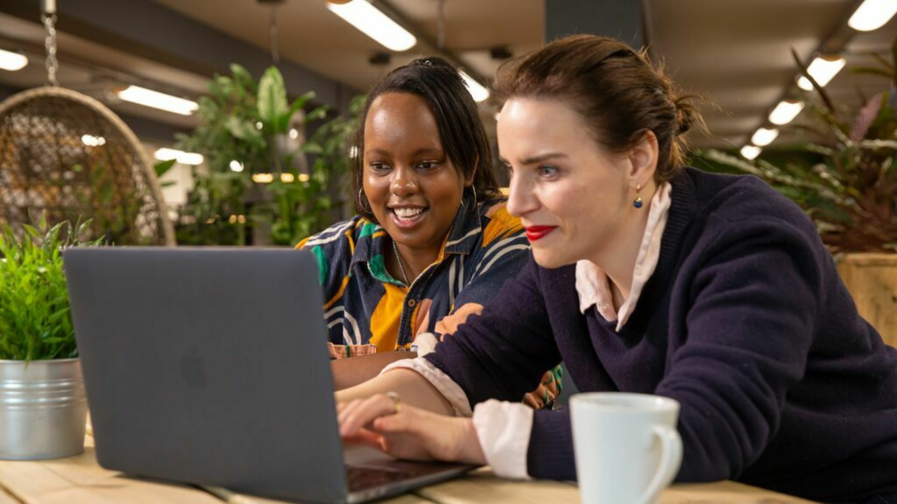 Two women looking at a laptop.