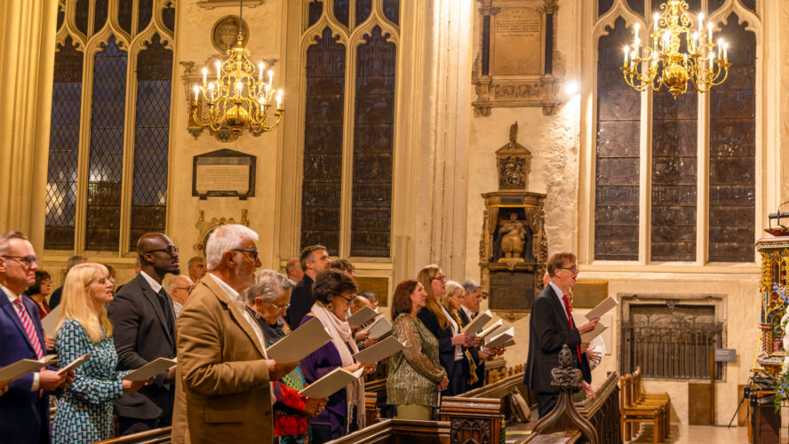 A church service held at Westminster Abbey, with a congregation stood up singing