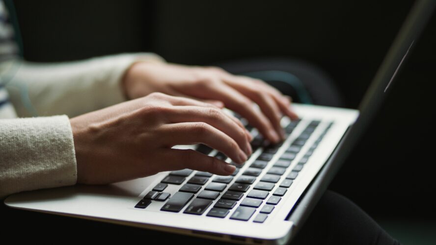 Hands typing on a laptop.