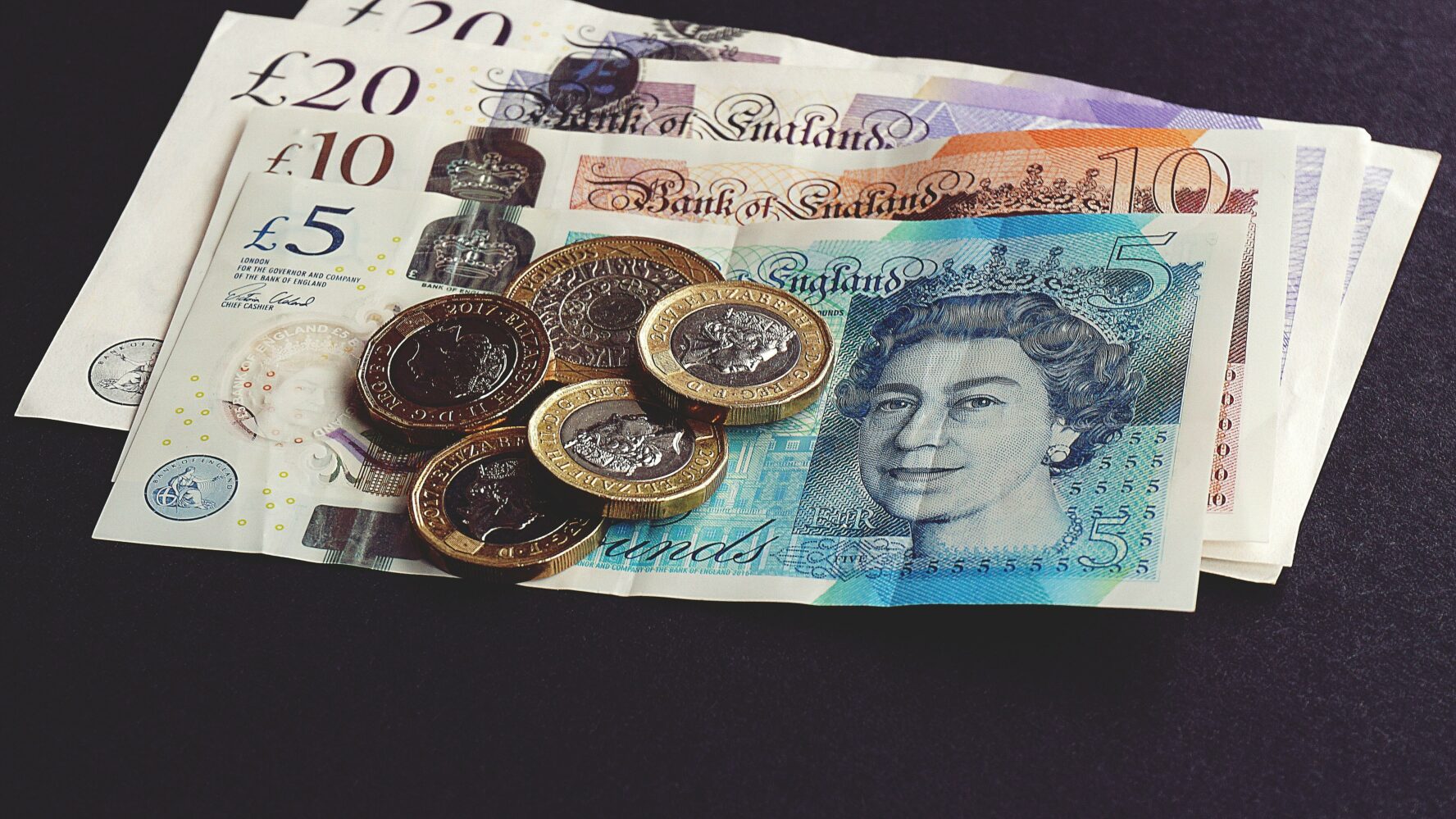 A pile of money including notes and coins.