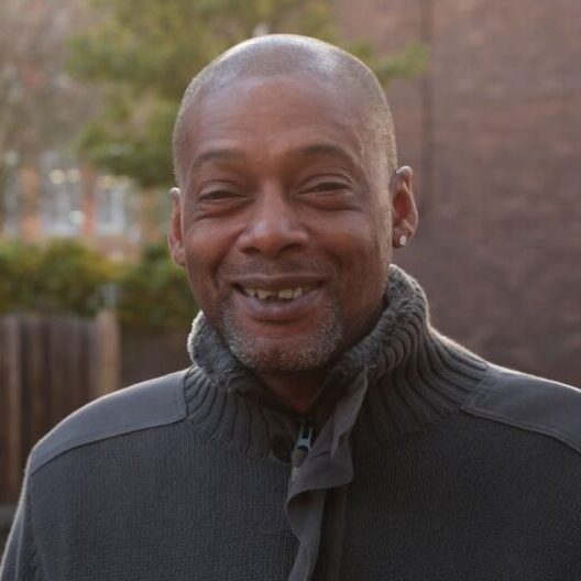 CAP client, Paul, stood outside, wearing a grey jumper and smiling at the camera