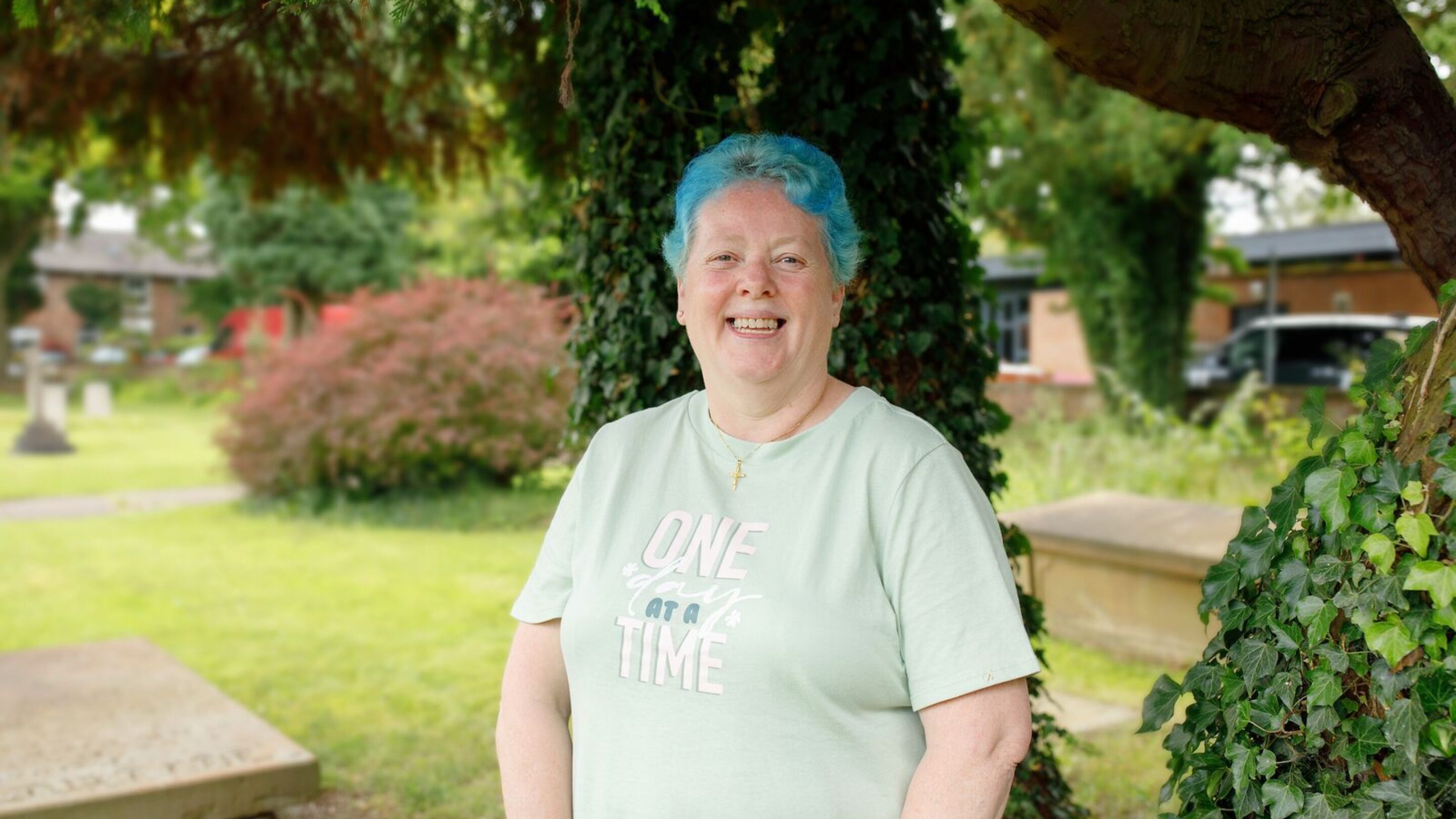 CAP client, Bea, stood outside in her church's garden, smiling at the camera
