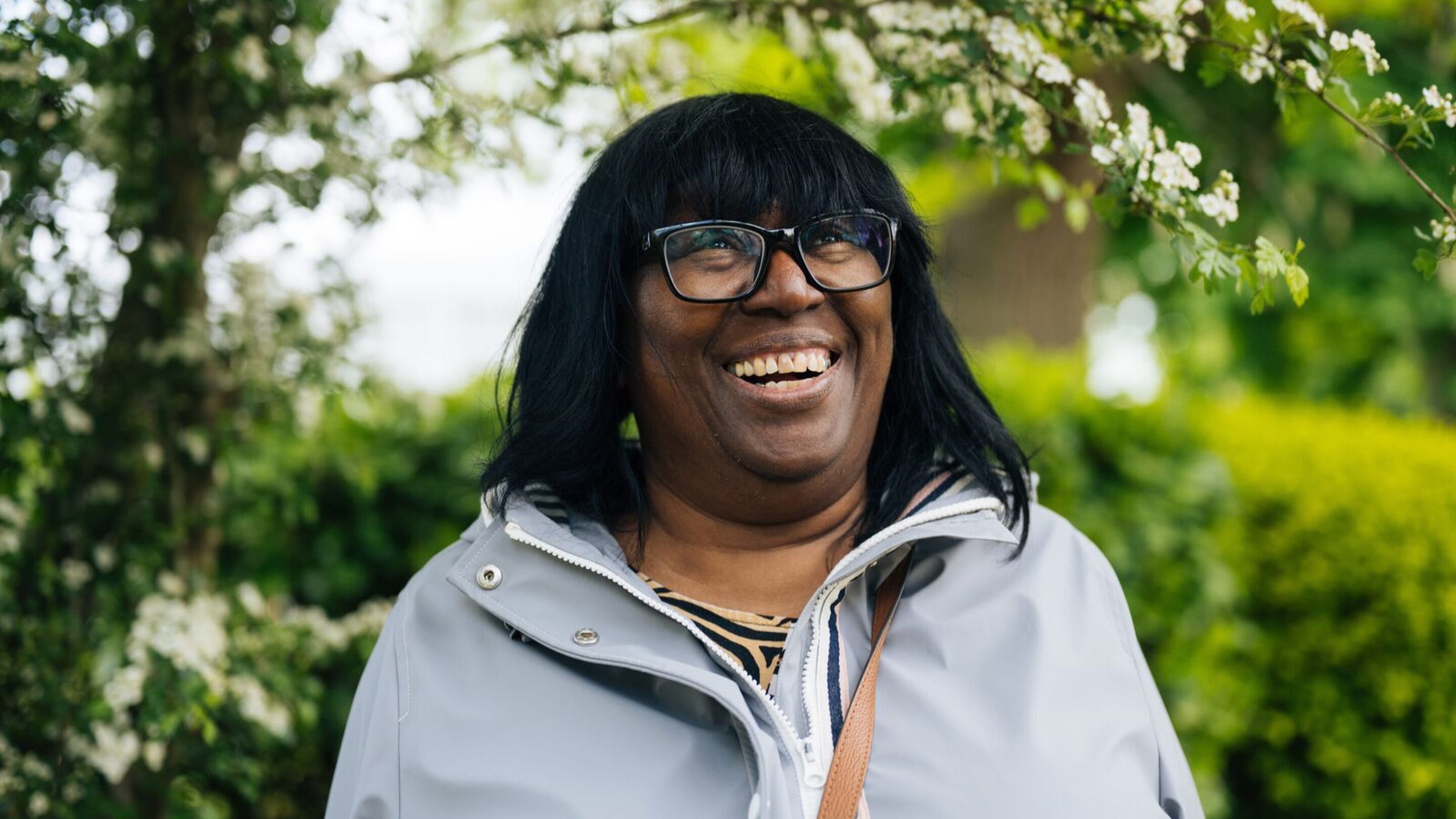 CAP client, Melinda, stood outside in a garden, looking up and smiling