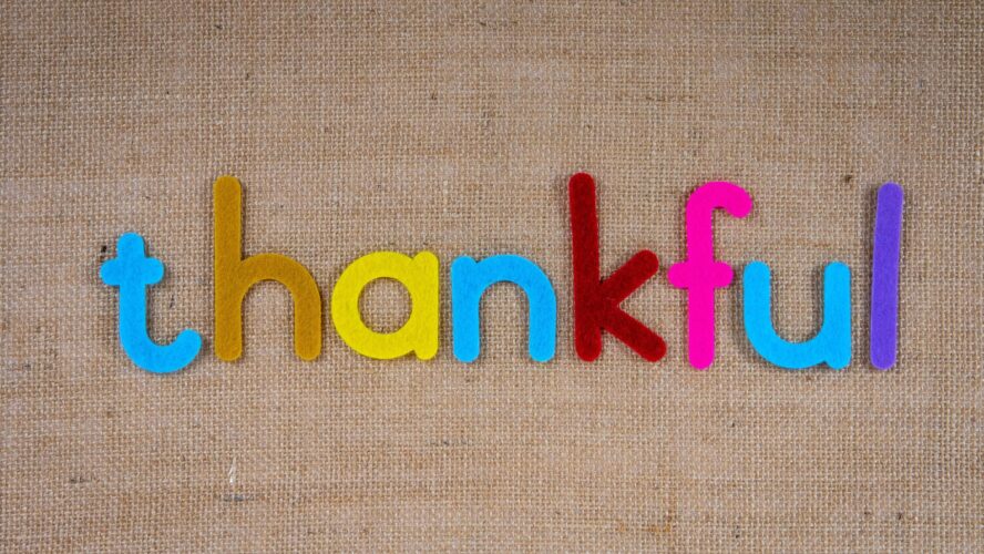 the word thankful is spelled out in colourful letters on a brown background