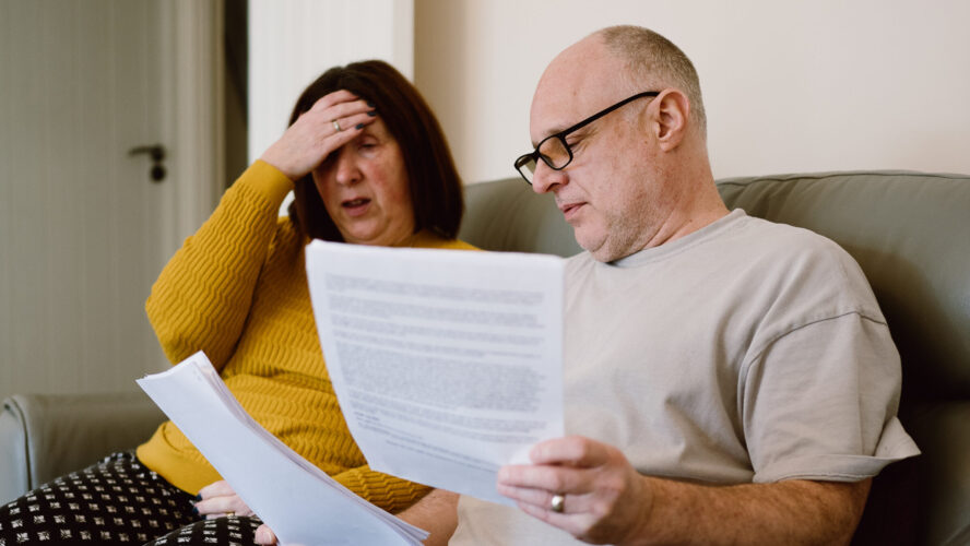 CAP client, Angela, sat on her living room sofa next to her husband, looking at bills and paperwork.