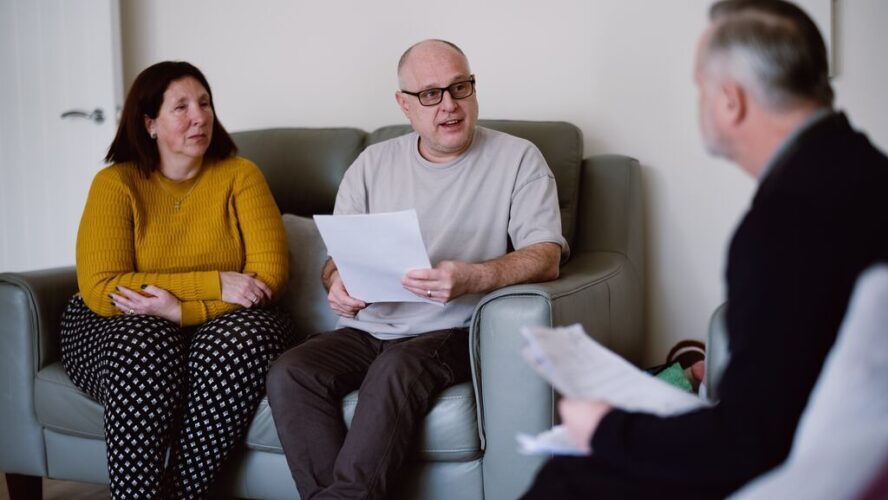 CAP client, Angela, and her husband sat in their living room, speaking to their debt coach and holding paperwork