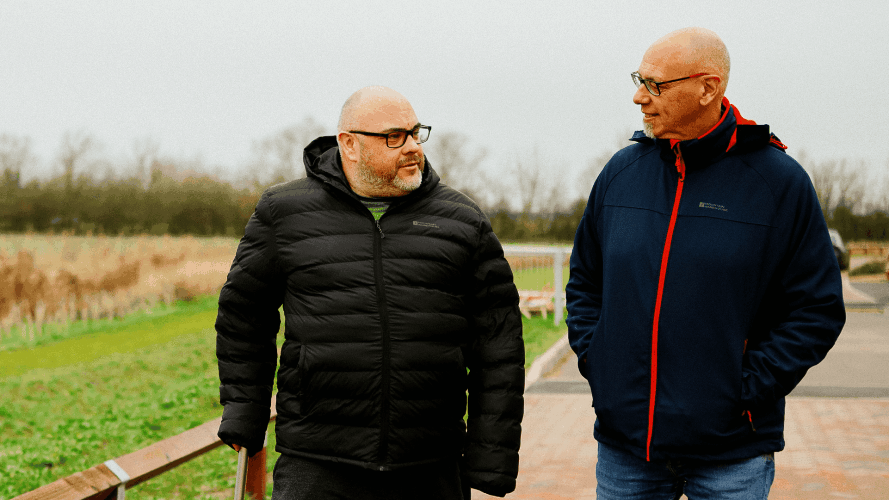 two men walking and chatting on a field