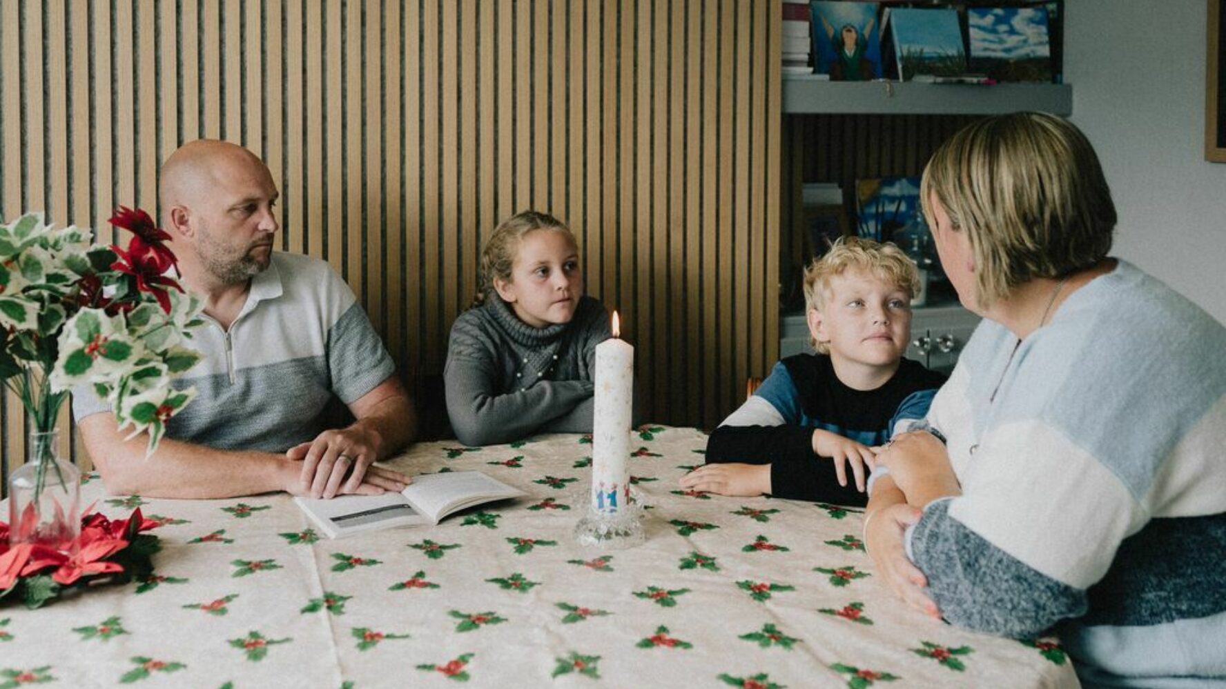 IA family sat around a dining table, with the parents talking to their children who are listening