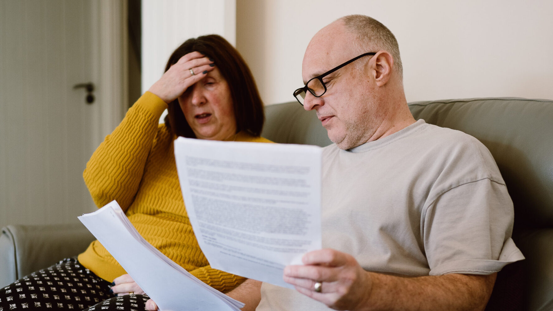CAP client, Angela, sat on her living room sofa next to her husband, looking at bills and paperwork.