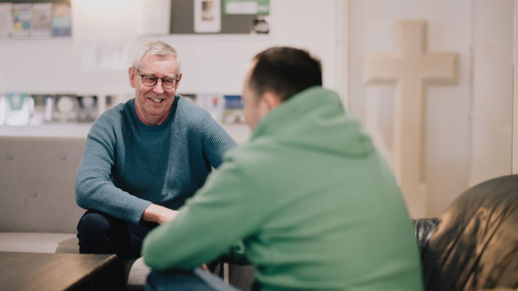 CAP debt coach sat with a client in his local church, smiling at each other